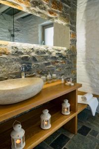 a bathroom with a sink and a stone wall at Maris Private Residence in Chora Folegandros