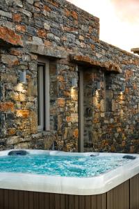a jacuzzi tub in a stone building at Maris Private Residence in Chora Folegandros