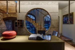 Zimmer mit einem Tisch, einem Stuhl und einem Spiegel in der Unterkunft Hotel Borgo Impero in Borgonovo Val Tidone