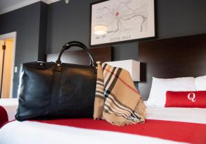 a black purse sitting on top of a bed at The Queensbury Hotel in Glens Falls