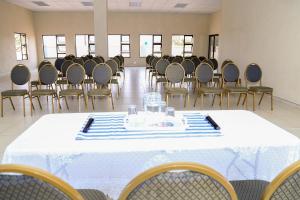 a room filled with chairs and a table with a white table cloth at Lempitse Lodge in Moletlane