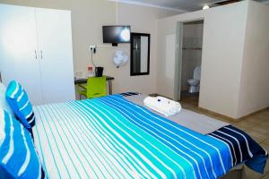 um quarto com uma cama listrada em azul e branco em Lempitse Lodge em Moletlane