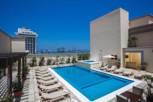 a swimming pool on the roof of a building with lounge chairs and a building at Fiesta Inn Veracruz Malecon in Veracruz