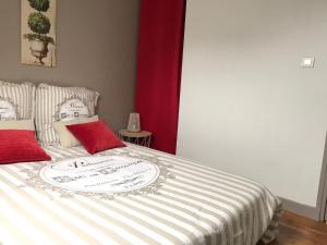 - un lit avec une pancarte et des oreillers rouges dans l'établissement Logement à Brive, proche centre-ville et gare, avec Netflix - internet fibre - Stationnements gratuit, à Brive-la-Gaillarde