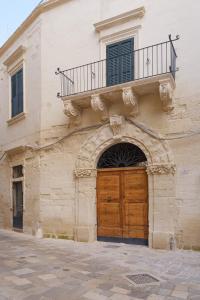 a building with a wooden door and a balcony at Italianway - Morelli 3 in Lecce