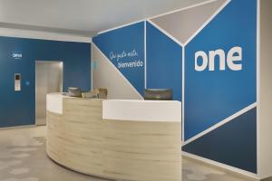 an office reception desk with a one sign on the wall at One Acapulco Diamante in Acapulco