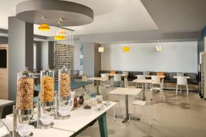 a restaurant with white tables and white chairs and food at One Acapulco Diamante in Acapulco