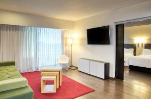 サカテカスにあるFiesta Inn Zacatecasのベッドとテレビが備わるホテルルームです。