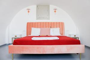 duże pomarańczowe łóżko z czerwonym kocem w obiekcie The Lighthouse Sunset View Suites w Akrotiri