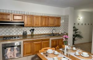 a kitchen with wooden cabinets and a table with chairs at Casa Aprea in Sorrento