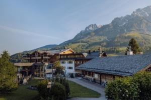 a group of buildings with mountains in the background at Naturresort PURADIES in Leogang
