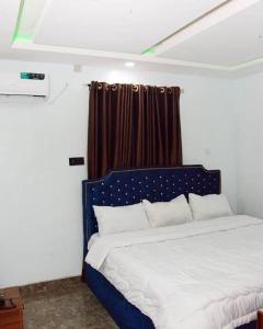 a bedroom with a blue and white bed with a window at Lords&ladies suites in Lagos