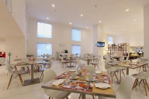 a dining room with tables and chairs and windows at Fiesta Inn Naucalpan in Mexico City