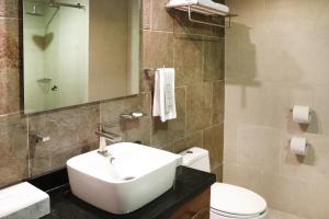 a bathroom with a white sink and a toilet at Gamma Mazatlan The Inn At Centro Historico in Mazatlán