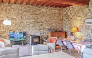 a living room with a stone wall and a table and chairs at 3 Bedroom Lovely Home In Gonneville-le-theil in Gonneville