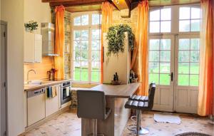 een keuken met een tafel en een bos ramen bij 3 Bedroom Lovely Home In Gonneville-le-theil in Gonneville