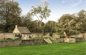 a house in a field with a stone wall at 3 Bedroom Lovely Home In Gonneville-le-theil in Gonneville