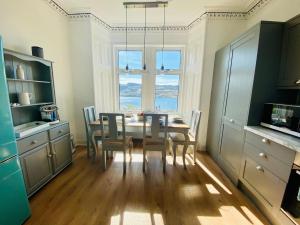 a dining room with a table and chairs in a kitchen at Upper Villa, Tighnabruiach, Argyll & Bute in Tighnabruaich