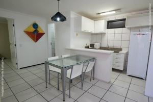 a kitchen with a glass table and white appliances at Porto de Iracema Vista Mar in Fortaleza