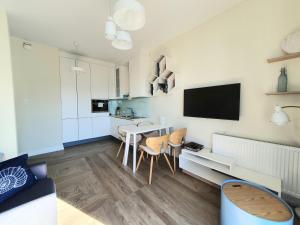 a kitchen and living room with a table and chairs at Live & Travel Apartments Number 1 in Gdańsk