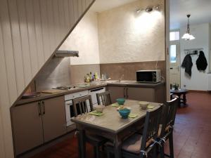 uma cozinha com uma mesa com cadeiras e um lavatório em Chez Louise em Guise