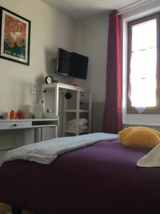 Schlafzimmer mit einem Bett, einem TV und einem Fenster in der Unterkunft L auberge du lion d or in Nanteuil-sur-Marne