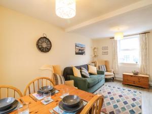 ein Wohnzimmer mit Tisch und Couch in der Unterkunft Guinea Cottage in Weymouth