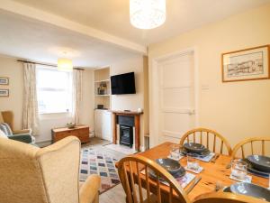 ein Esszimmer mit einem Holztisch und Stühlen in der Unterkunft Guinea Cottage in Weymouth