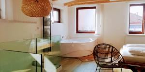 a bathroom with a tub and a glass table at Apartmány Cechovní in Moravská Třebová