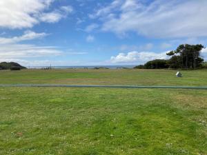 a field of green grass with a road at Tillicum Beach Motel - Formerly Deane's Oceanfront Lodge in Yachats