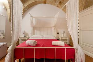 コペルティーノにあるB&B La Uliaのベッドルーム1室(赤いベッド1台、白いタオル2枚付)