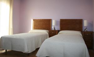 two beds sitting next to each other in a room at Hostal La Cerollera in Cerollera