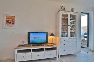 a living room with a tv on a white cabinet at Appartementanlage am Taschensee Taschensee Appartement 9 in Gronenberg
