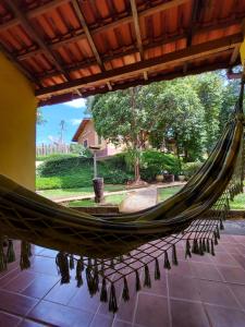 a hammock in a house with a view of a yard at Pousada Aconchego do Caboclo in Monteiro Lobato