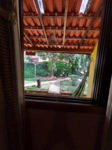 a window in a room with a view of a yard at Pousada Aconchego do Caboclo in Monteiro Lobato