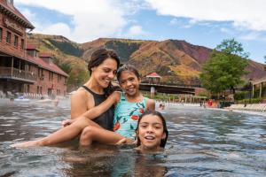 a woman and a man are standing in the water at Glenwood Hot Springs Resort in Glenwood Springs