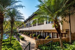 un edificio con palme di fronte di Villa di Mantova Resort Hotel ad Águas de Lindóia