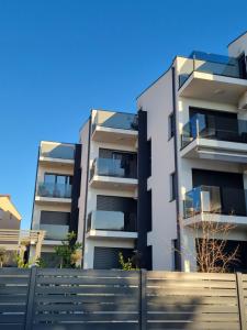 um edifício de apartamentos com uma cerca em frente em Sea View Medulin Apartment - Orijeta em Medulin