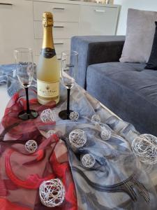 Sea View Medulin Apartment - Orijeta في ميدولين: زجاجة من النبيذ وكأسين على الطاولة