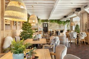 a restaurant with tables and chairs and a christmas tree at Osrodek Wypoczynkowy Lesniczówka & Elias SPA in Istebna