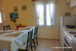 uma cozinha com uma mesa com uma toalha de mesa branca em Adonino Residence-The House of Pomegranates em Lakíthra