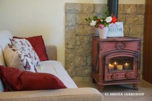 uma sala de estar com um sofá e um fogão a lenha em Adonino Residence-The House of Pomegranates em Lakíthra