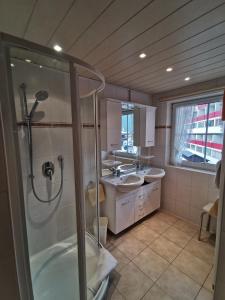 een grote badkamer met 2 wastafels en een douche bij Gästehaus Thaler in Mittelberg