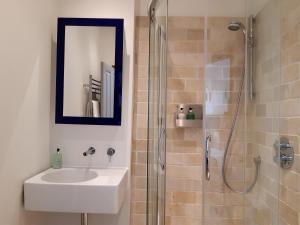 a bathroom with a sink and a shower with a mirror at Browns Hotel in Dartmouth