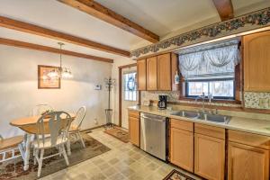a kitchen with a sink and a table and a table and chairs at The Lakehouse Lovely Wappapello Country Home! in Wappapello