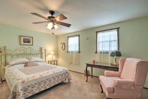 a bedroom with a bed and a chair and a ceiling fan at The Lakehouse Lovely Wappapello Country Home! in Wappapello