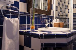 a blue and white bathroom with a sink and a mirror at Casa Rural La Loma in Nohales