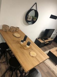 a wooden table in a room with a mirror at Paisible logement à Brive proche centre-ville et campagne avec Wifi Netflix et Parking privé in Brive-la-Gaillarde
