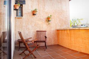 eine Terrasse mit 2 Stühlen, einem Tisch und einem Fenster in der Unterkunft Casa Rural La Loma in Nohales