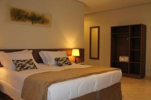 a bedroom with a large bed with two pillows at Hotel Fazenda Pirâmides in Atibaia